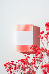 Bar of homemade soap with label on a white background. Mockup for design. Skin care cosmetic with red flowers. Beauty concept for face body care