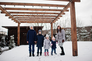 Attractive mother with her four kids in winter day.