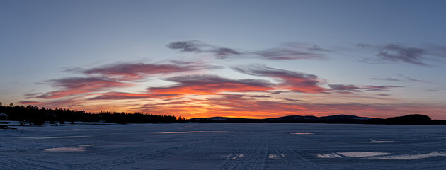 Panorama coucher de soleil sur un lac gelé en Laponie finlandaise. 