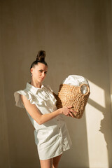 Young slender girl with a wicker basket Ukrainian woman sitting on the floor on a round rug looks to the mirror hair gathered in a stylish hairstyle has brown eyes beautiful face on her arm bracelet