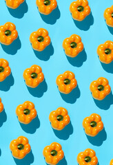 Graphic top view background of fresh yellow vegetables pattern on vibrant blue background, healthy eating and vegan concept