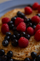 plate with pancakes and berries on a wooden table