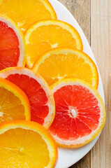 Sliced orange and grapefruit slices on a white plate. Vertical photography. healthy food concept. Natural vitamins in food.