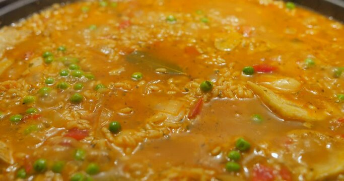 Close up view of exotic meal of fried rice with carrots and green peas been cooked in a kitchen.