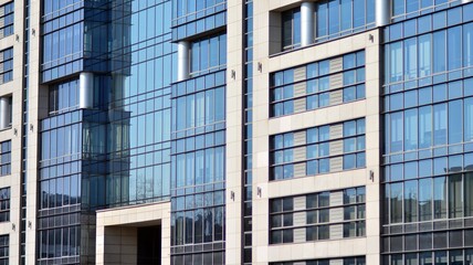 Perspective view to steel and  blue glass. Commercial modern city of future. Business concept of successful industrial architecture. The sunlight falling on the building.