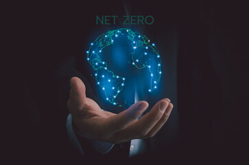 Businessman selecting icon world and text net zero. Eco friendly business and development concept on virtual screen.
