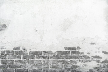 Old brick wall with peeling cracking cement plaster, grunge background.