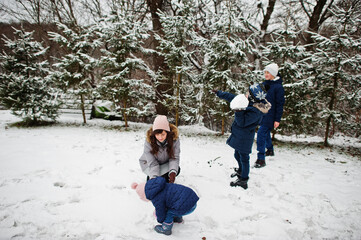 Attractive mother with her four kids in winter day.