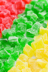 Backdrop diagonal lines of red, yellow and green candied fruits - natural sweets with sugar