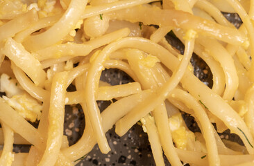 Noodles fried in a pan.