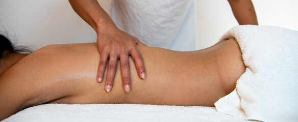 Junge Frau bekommt eine Wellness Thaimassage mit Aromaölen in einem Massagesalon 