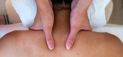 Junge Frau bekommt eine Wellness Thaimassage mit Aromaölen in einem Massagesalon 