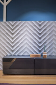 lacquered cool gray low rack against geometric zigzag wallpaper