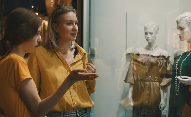 Family looking at the shop window of clothing store.