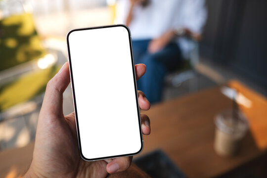 Mockup image of a man holding mobile phone with blank white screen with a woman in background