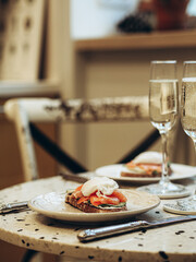 Sunday brunch with prosecco and eggs and salmon bruschetta on marble table