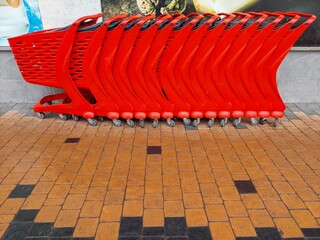 Obraz premium A row of large shopping carts from the supermarket. Purchases and sales. Supermarket business. Shopping complex. A hand cart.