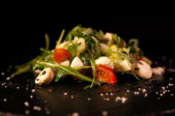 A fresh vegetable salad. A mix of tomatoes, green lettuce, arugula, radishes and seeds. Healthy vegetarian food