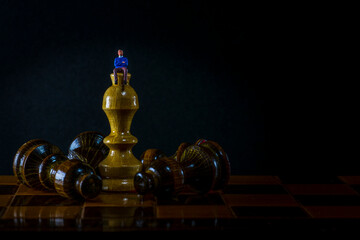 White chess King standing and fallen black chess pieces. Winner of business competition planning concept and marketing strategy. Macro