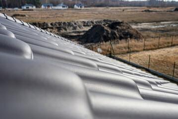 The roof of a single family house is covered with new anthracite ceramic tiles, visible from above.