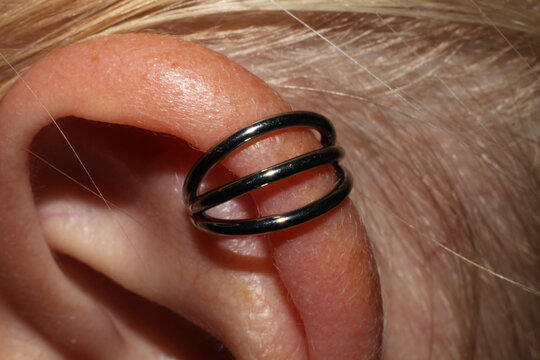 Completely healed ear cartilage piercing + titanium triple ring. Macro.