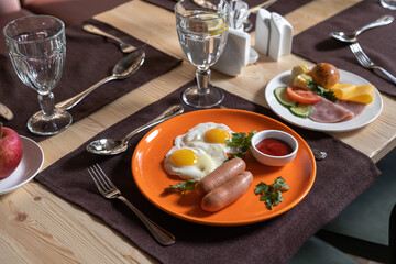 Fried eggs with sausages and tomato sauce.