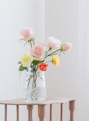 beautiful roses in glass jug on white background