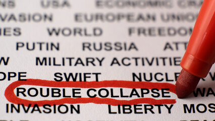 Closeup shot of ROUBLE COLLAPSE written on white paper with a red circle. Russian invasion of...