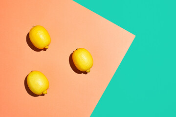Graphic top view of fresh yellow lemons on vibrant contrasted background, healthy eating and vegan concept, copy space