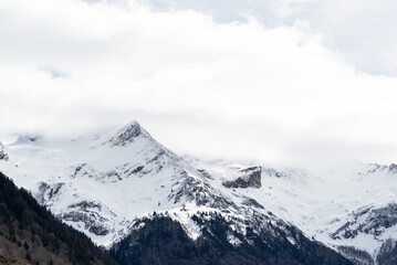 Snowy mountain with white cloudy sky in french Pyrenees. 