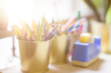 color pencils in bucket on table beside window selective focus