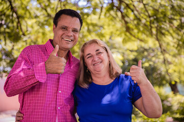 Older dating couple with thumbs up smiling