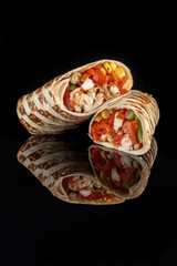 Burritos wraps with beef and vegetables on black background. Beef burrito, mexican food. Vertical photo