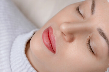 Permanent make-up of lips, eyebrows and eyes, woman on tattoo procedure