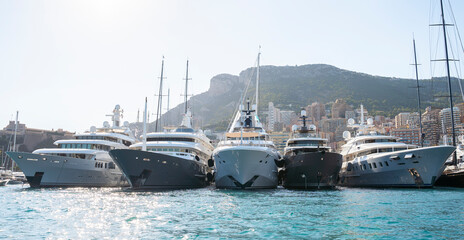 Super Yachts moored in Monaco harbour with Monaco landscape on a background	
