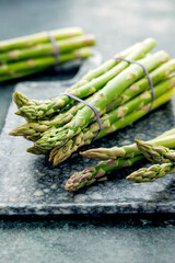 Bunch of green asparagus on a rustic background, fresh farm vegetables at the farmers market