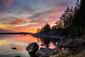 Sunset in Karelia, on Lake Ladoga, in the foreground stones in the background mountains.