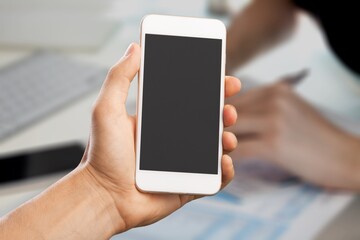 Human hand text messaging on mobile phone during a class at the university.