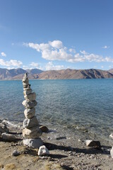 Stone pyramid nearby the water of the pangong tso lake in the region of Ladakh in India 