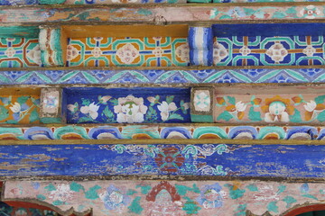Colorful buddhist paintings on a wooden wall in asia
