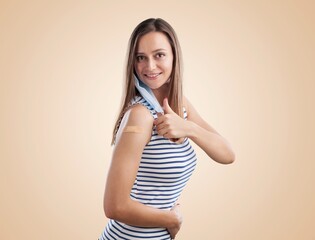 A woman showing shoulders after getting a vaccine. Happy with band-aids on after vaccine injection.