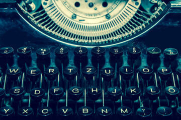 The detail picture of the old retro mechanical typewriter in retro faded colors. 