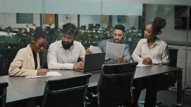 Creative professional multiethnic business team diverse partners workers colleagues in office space working on startup project discussing analyzing financial data paperwork documents strategy ideas