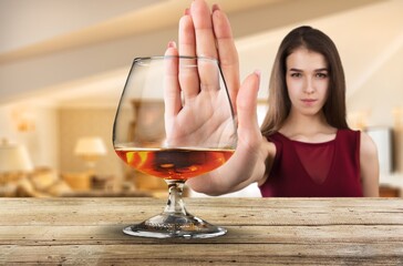 Alcoholism, sad depressed young woman refuse, push alcoholic beverage glass, drink whiskey, sitting alone - obrazy, fototapety, plakaty