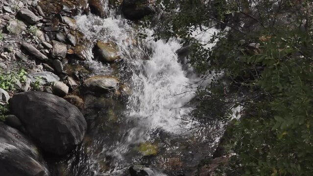 Rio Maitena en la Sierra de G&uuml;ejar en Granada, descendiendo entre rocas con un &aacute;rbol con hojas mecidas por el viento