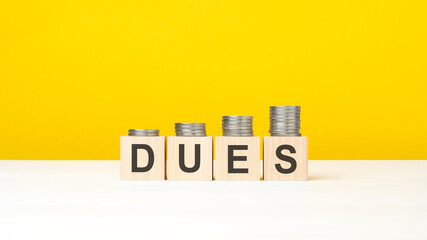 text dues on wooden cubes on yellow background