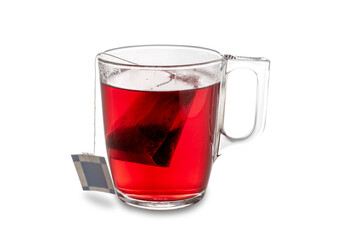 Red fruit herbal tea, herbal tea infusion bag in transparent glass cup isolated on white, clipping path