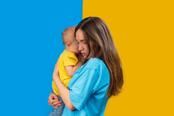 YOUNG MOTHER WITH HER CHILD IN THE COLORS OF UKRAINE