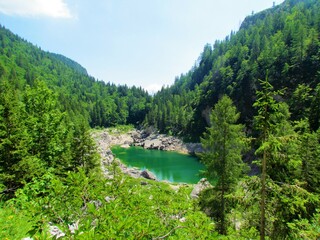 Fototapeta na wymiar Scenic view of the Black lake, Komarca or Crno jezero in Triglav lakes valley in Triglav national park and Julian alps in Slovenia on a sunny day