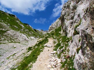 High alpine valley in Triglav national park and Julian alps, Slovenia with a path leading towards Zelnarica and Prehodavci covered in rocks and mountain meadows